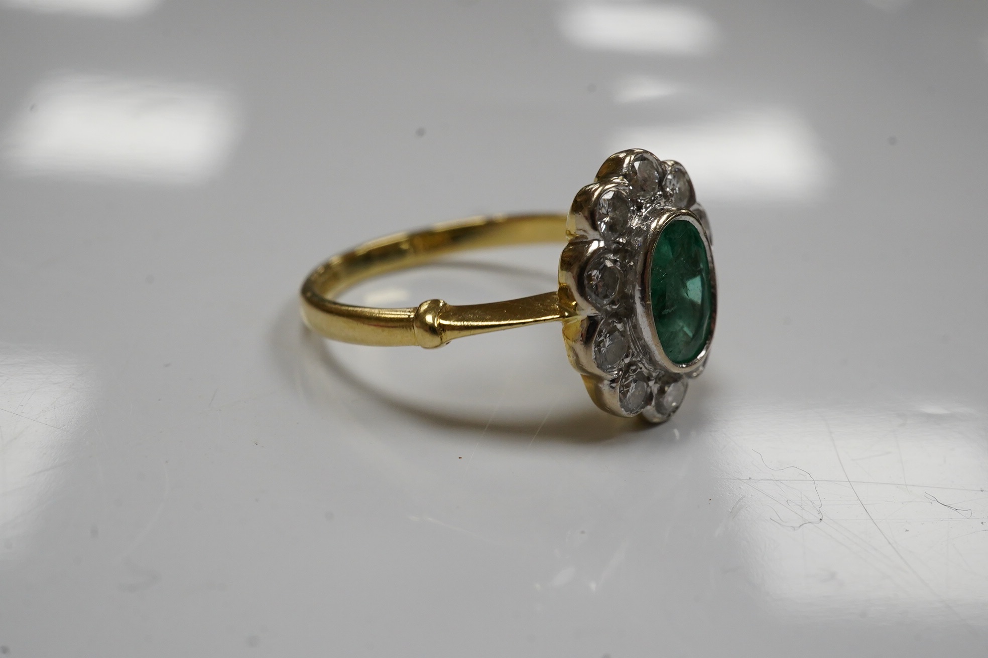 A modern 18ct gold, emerald and diamond set oval cluster ring, size L, gross weight 3.5 grams. Condition - poor to fair